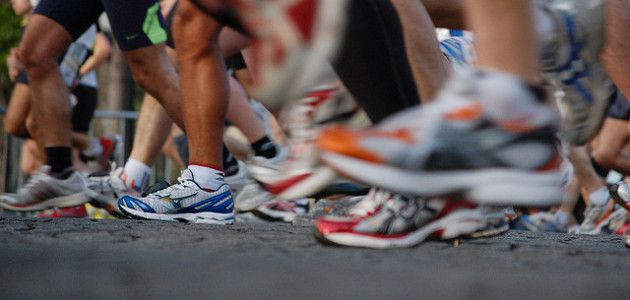 dozens of running shoes hitting the pavement or in motion.
